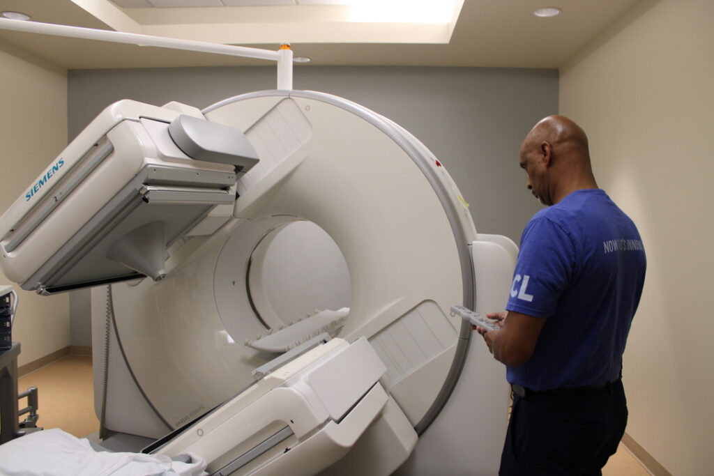 technician servicing CT scanner imaging equipment in healthcare facility